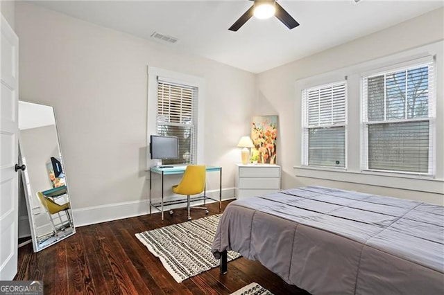 bedroom with baseboards, multiple windows, visible vents, and wood finished floors