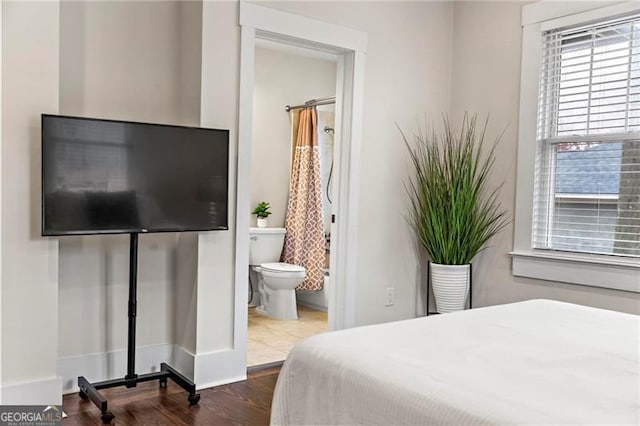 bedroom featuring dark wood-style floors and connected bathroom