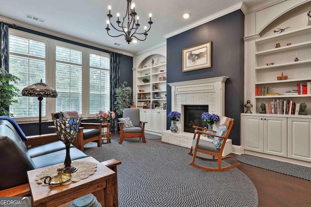 sitting room featuring visible vents, baseboards, built in features, crown molding, and a brick fireplace