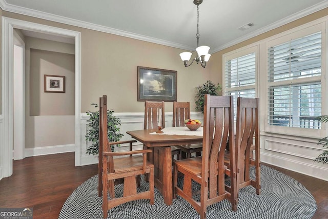 dining room featuring a chandelier, wood finished floors, visible vents, ornamental molding, and wainscoting