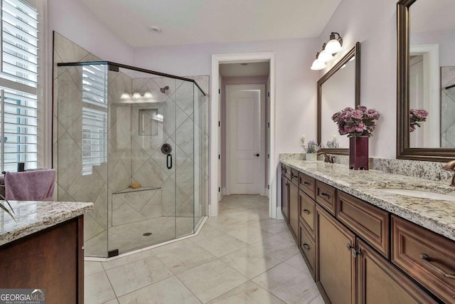 full bathroom with double vanity, a stall shower, and a sink