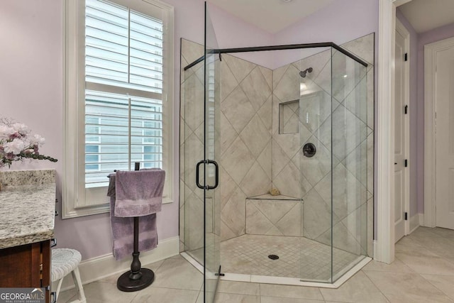 full bathroom featuring a stall shower, a wealth of natural light, tile patterned flooring, and vanity