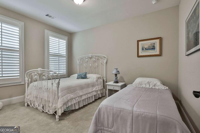 bedroom featuring carpet floors, visible vents, and baseboards