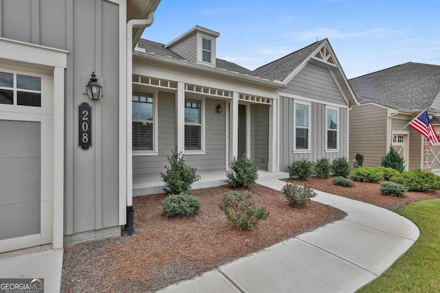 property entrance featuring board and batten siding and covered porch