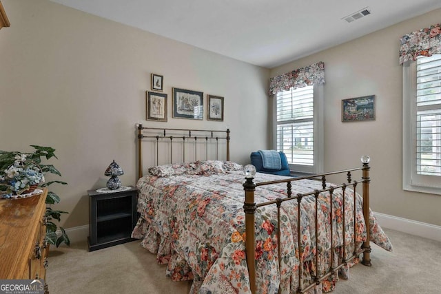 carpeted bedroom with visible vents and baseboards