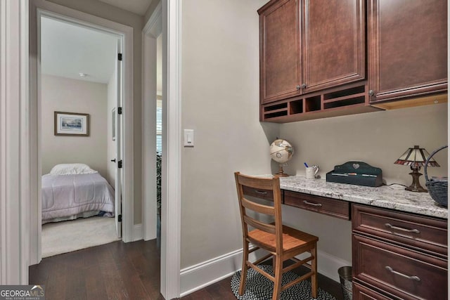 office with built in study area, dark wood finished floors, and baseboards