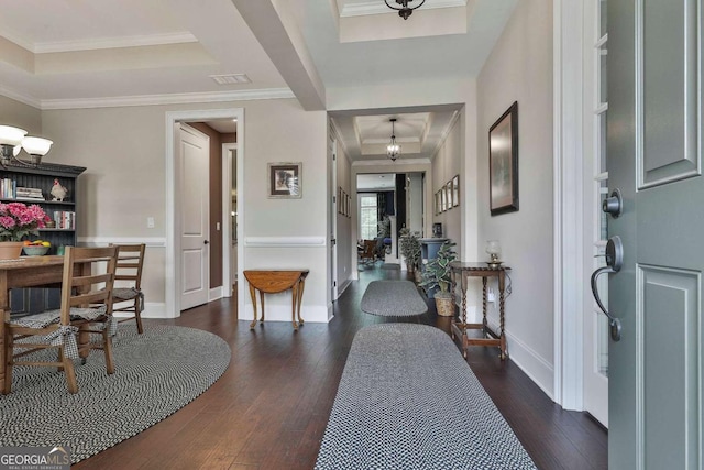 entryway with ornamental molding, a raised ceiling, and hardwood / wood-style flooring