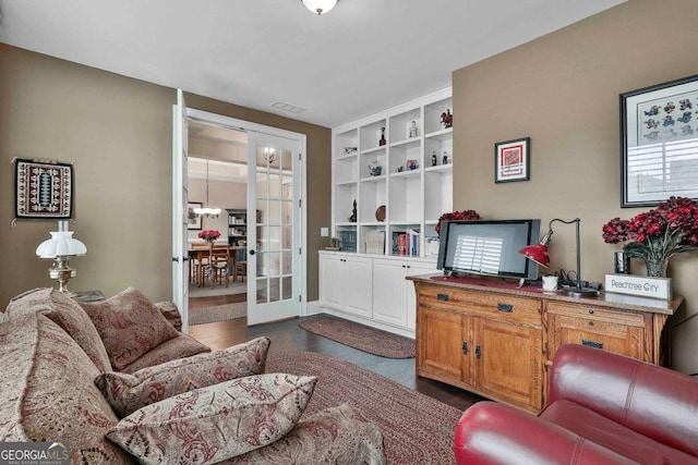 living room featuring french doors, dark wood-type flooring, and visible vents