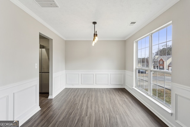 unfurnished dining area with ornamental molding, visible vents, dark wood-style flooring, and a textured ceiling