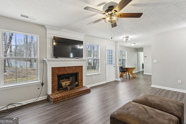 living room with plenty of natural light, wood finished floors, and visible vents