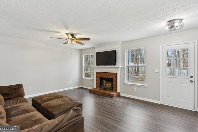 living area with a ceiling fan, a fireplace, dark wood-style flooring, and baseboards