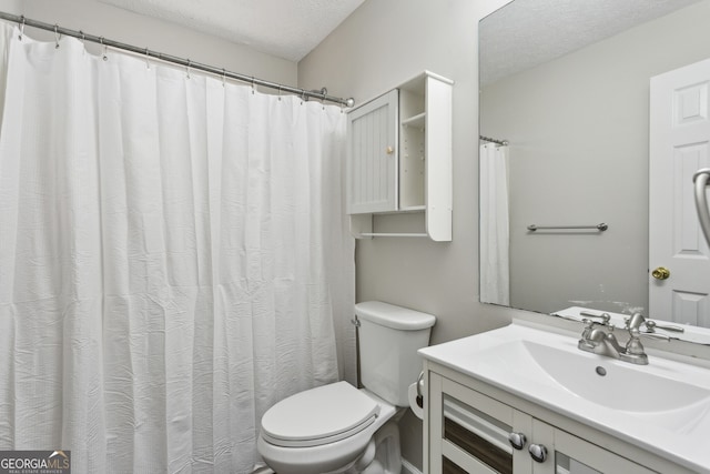 bathroom with a textured ceiling, toilet, and vanity