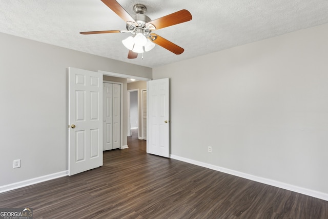 unfurnished bedroom featuring ceiling fan, dark wood-type flooring, baseboards, and a textured ceiling