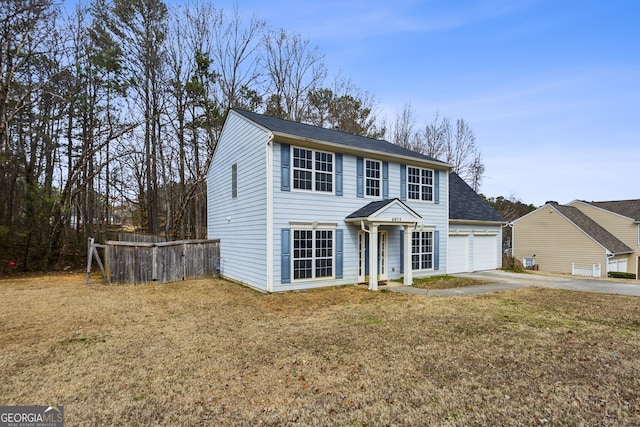 view of front of property featuring driveway, an attached garage, and a front lawn