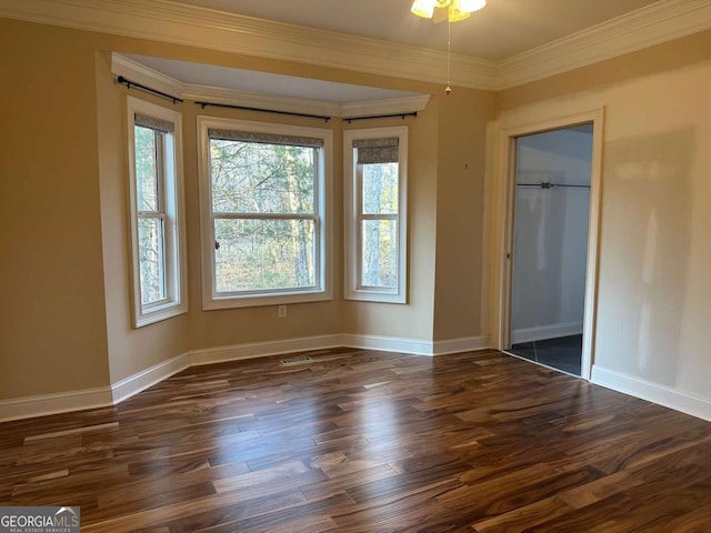 interior space with dark wood-type flooring, ornamental molding, and baseboards