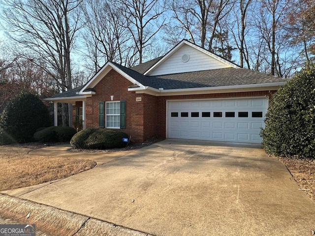 view of front of home featuring a garage, concrete driveway, brick siding, and a shingled roof