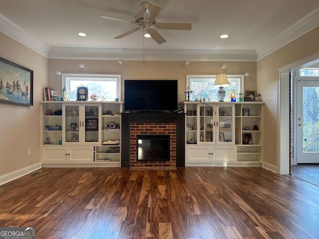 living area featuring crown molding, dark wood finished floors, a brick fireplace, and plenty of natural light