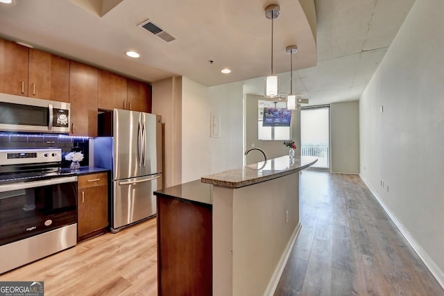 kitchen with visible vents, brown cabinets, appliances with stainless steel finishes, and light wood-type flooring