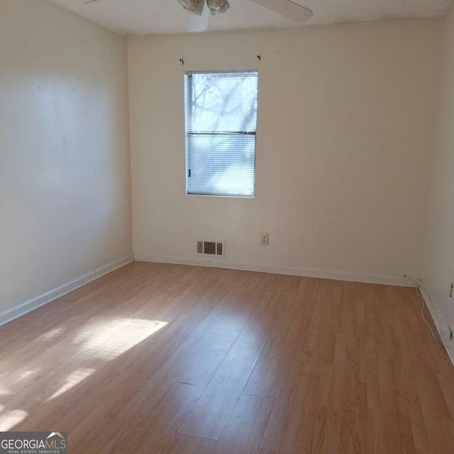 spare room with light wood-style floors, visible vents, ceiling fan, and baseboards