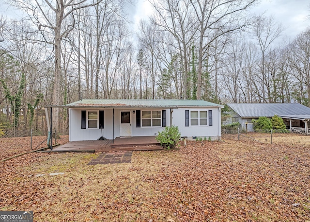 single story home featuring crawl space, metal roof, a porch, and fence