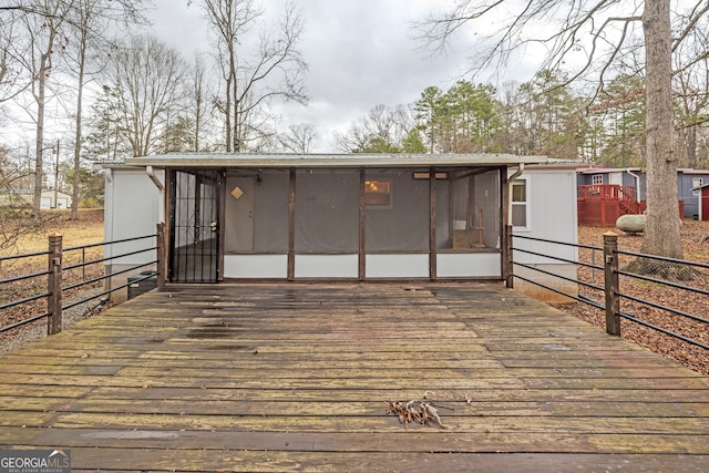 wooden deck featuring a sunroom and fence