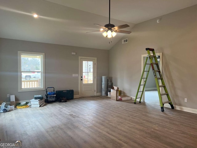 interior space featuring lofted ceiling, ceiling fan, wood finished floors, visible vents, and baseboards