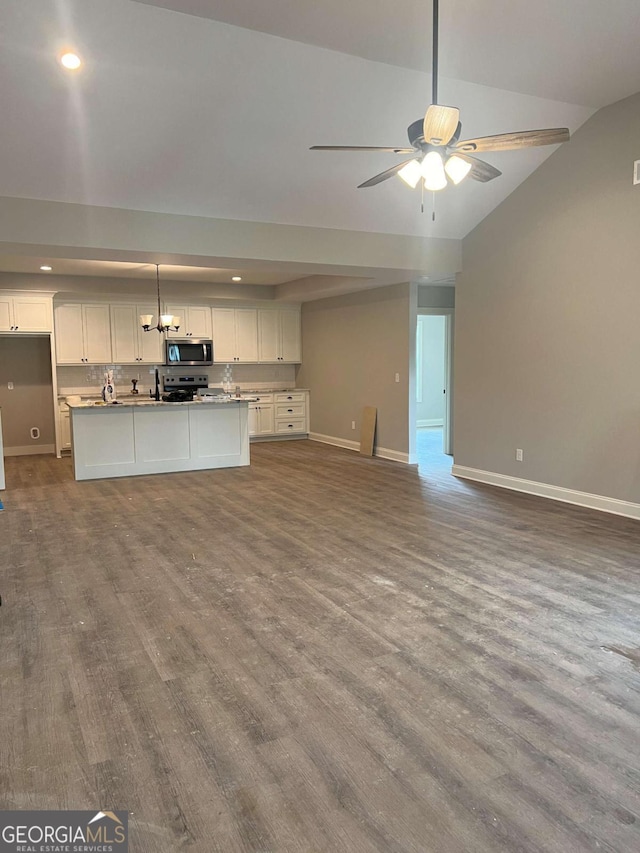 kitchen with appliances with stainless steel finishes, open floor plan, dark wood-type flooring, and white cabinets