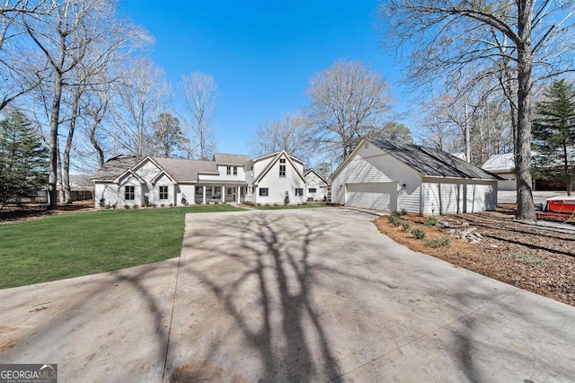 view of front of property with an outbuilding, a detached garage, and a front yard