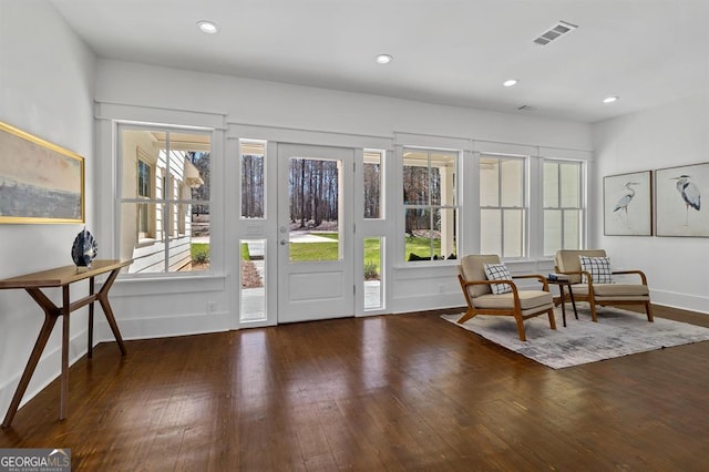 doorway to outside with a wealth of natural light, visible vents, and hardwood / wood-style floors