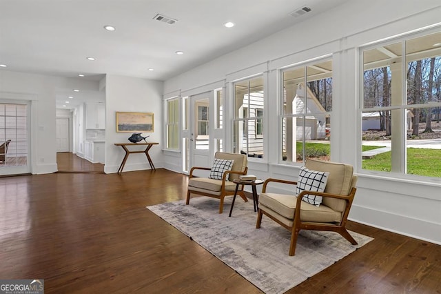 living area with visible vents, dark wood-type flooring, and recessed lighting