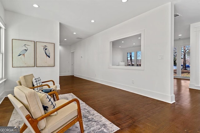 living area featuring baseboards, visible vents, dark wood-type flooring, and recessed lighting