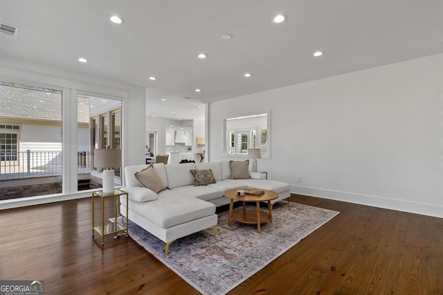 living room with plenty of natural light, dark wood finished floors, and recessed lighting