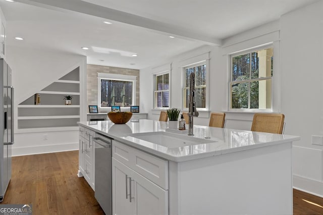 kitchen with an island with sink, dishwasher, a wealth of natural light, and dark wood-type flooring