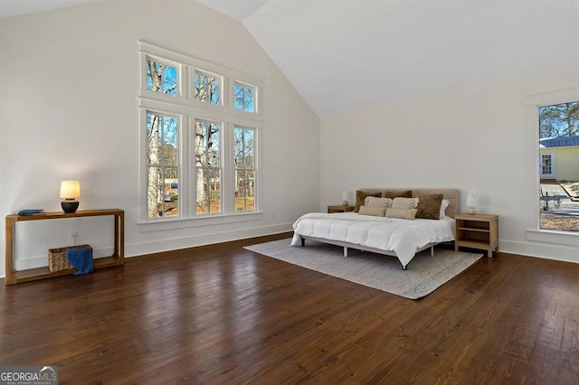 bedroom with high vaulted ceiling, baseboards, and wood finished floors