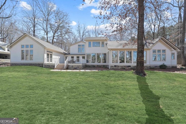 rear view of house featuring a deck and a yard