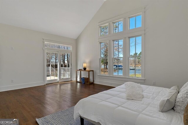 bedroom with high vaulted ceiling, access to exterior, baseboards, and wood finished floors