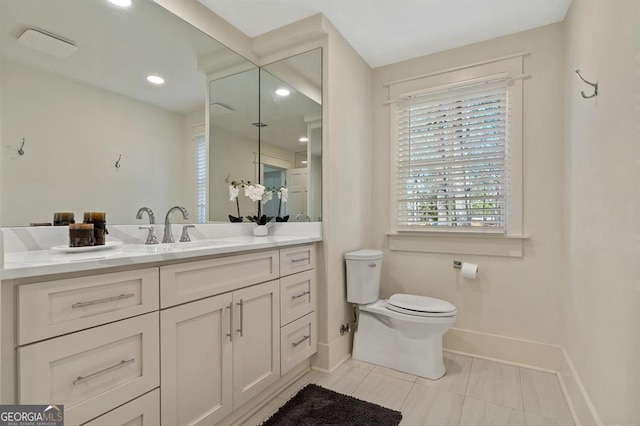 bathroom with toilet, tile patterned floors, baseboards, and vanity