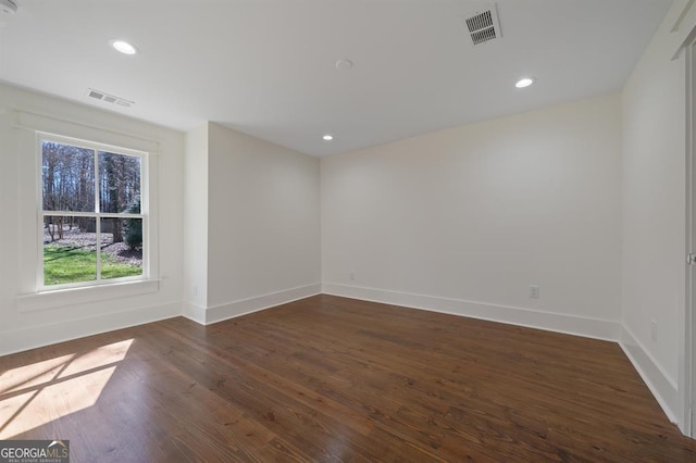 spare room with dark wood-style floors, recessed lighting, visible vents, and baseboards