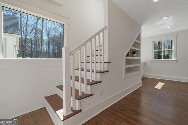 stairs with recessed lighting, wood finished floors, built in features, and baseboards