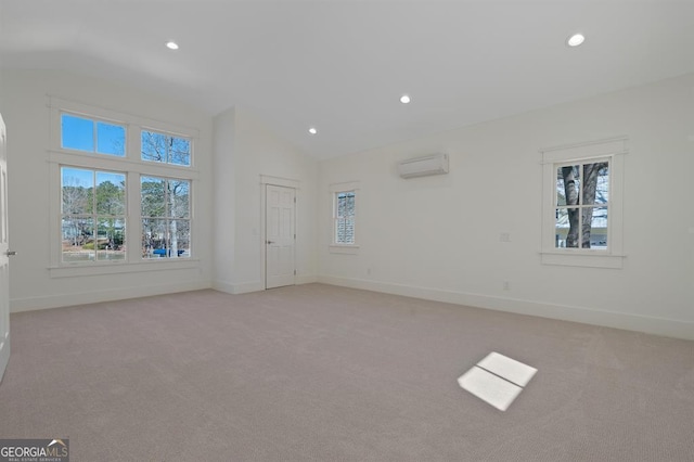 interior space with vaulted ceiling, an AC wall unit, and light colored carpet