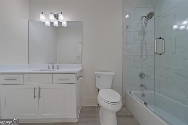 bathroom with toilet, shower / bath combination with glass door, baseboards, and vanity