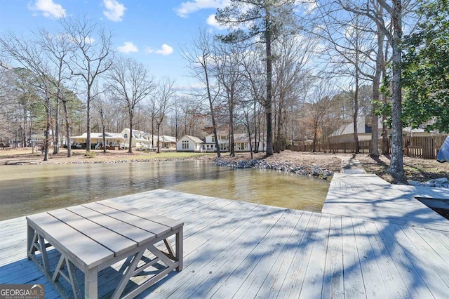 wooden terrace featuring a dock and fence