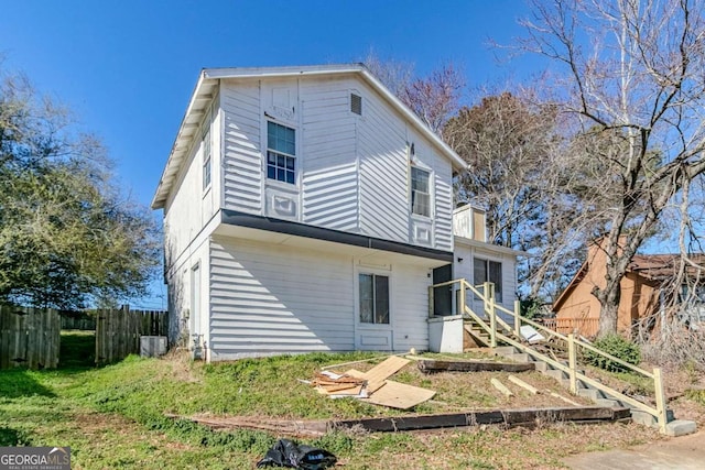 back of house with central AC and fence