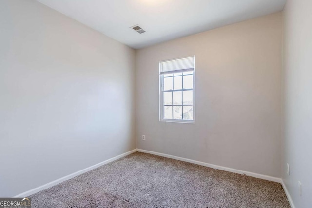 carpeted empty room featuring baseboards and visible vents