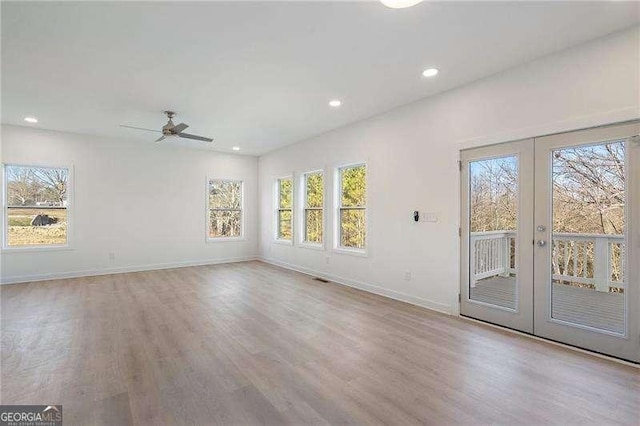 unfurnished living room with french doors, wood finished floors, and a wealth of natural light