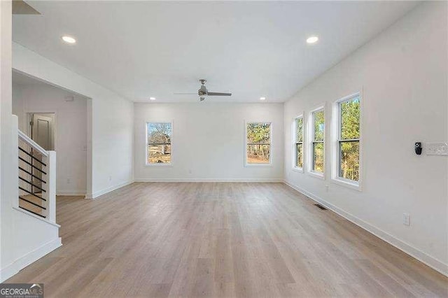 unfurnished living room featuring recessed lighting, visible vents, baseboards, stairway, and light wood finished floors