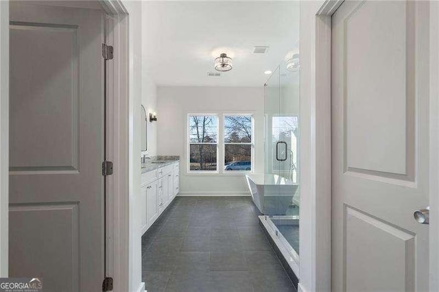 bathroom featuring a freestanding tub, baseboards, visible vents, and vanity