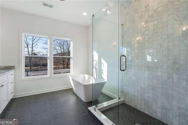 bathroom with tile patterned flooring, visible vents, baseboards, a soaking tub, and a stall shower