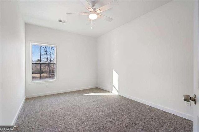 carpeted empty room with a ceiling fan, visible vents, and baseboards