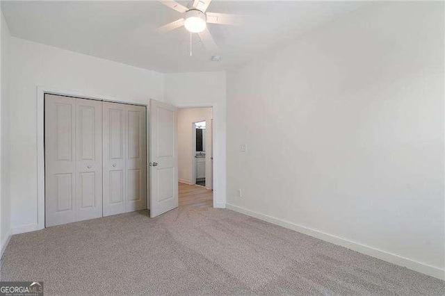 unfurnished bedroom featuring ceiling fan, baseboards, a closet, and light colored carpet